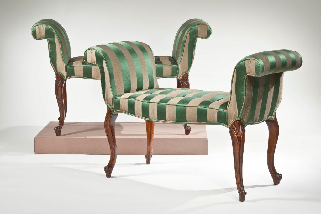 A Pair of George III mahogany window benches, each with out-scrolled sides and a serpentine front on fan-carved cabriole legs, one frame stamped “C”, the other “D”.