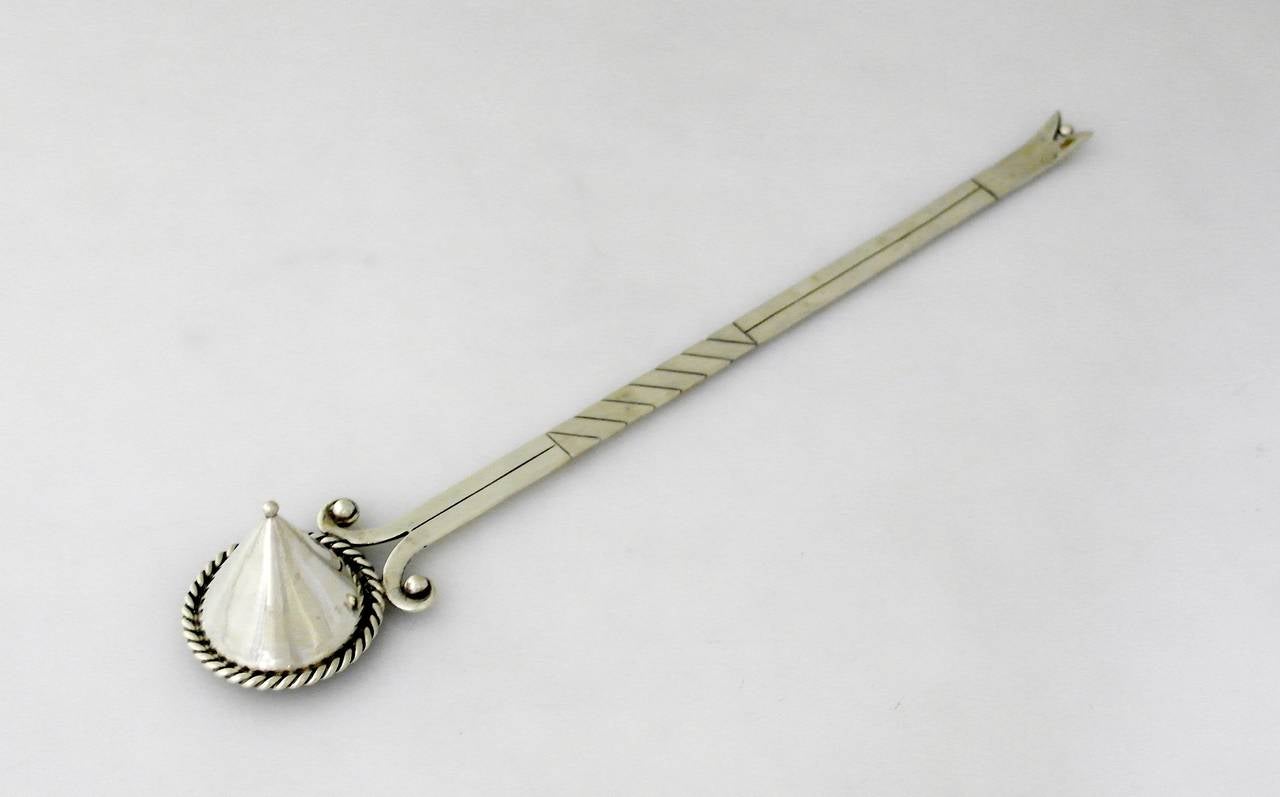 Being offered is a .940 silver candle snuffer by Hector Aguilar of Taxco, Mexico. Hand made piece by one of Taxco's master silversmiths; long handle decorated with incised lines, scroll form near the cone shaped bowl with rope design; beaded detail.