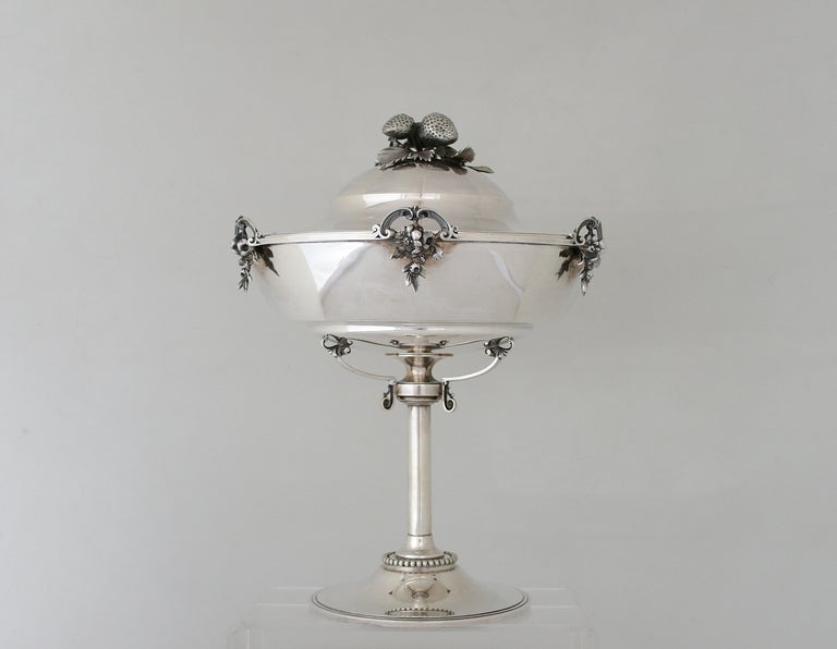 Being offered is a circa 1870 tazza by Gorham of Providence, Rhode Island, retailed by J.W. Tucker; the domed lid surmounted by a fruiting branch finial, the gilt interior engraved with central stylized foliage.   Weight 43 troy oz.   Dimensions