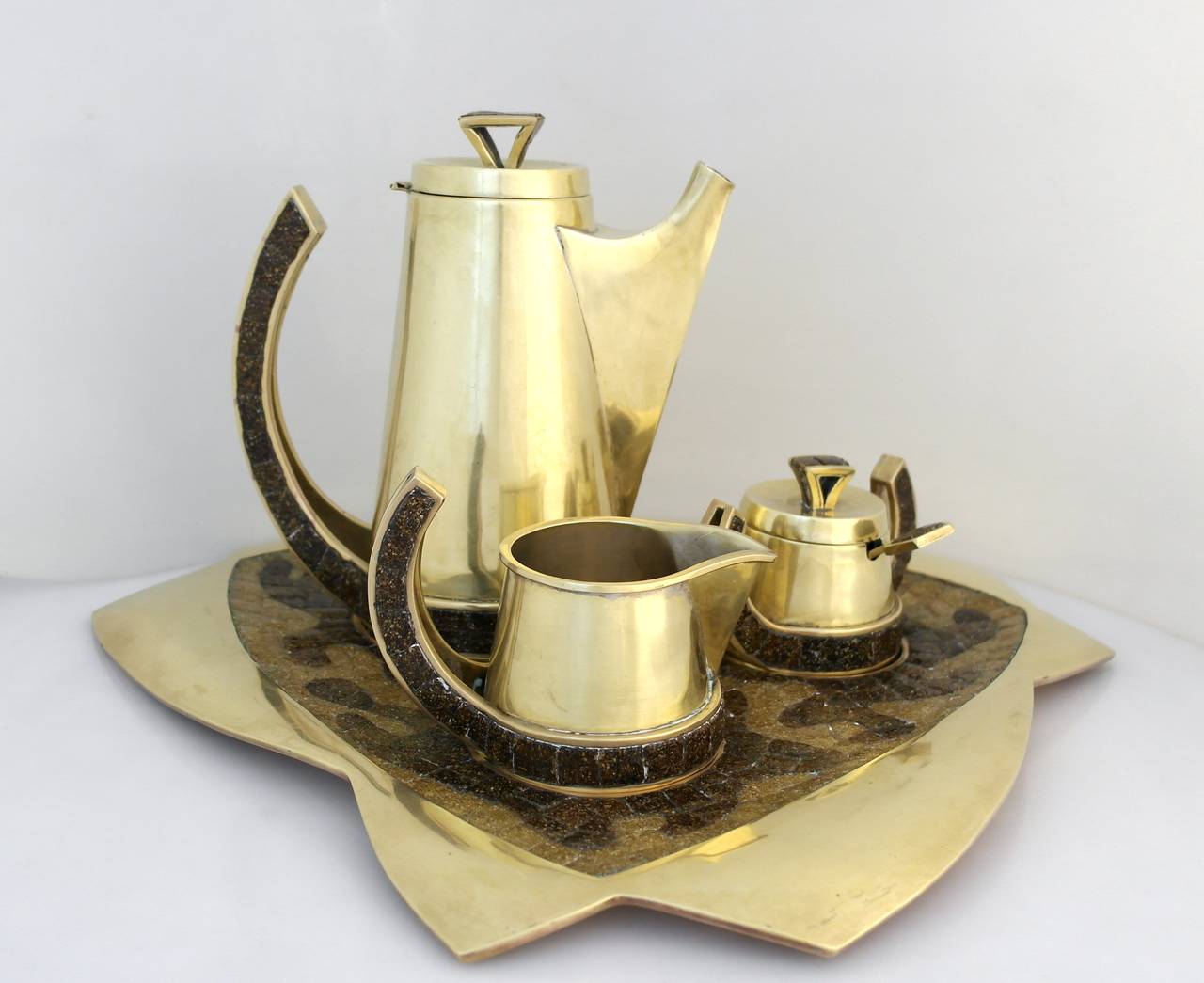 Being offered is a tea set, circa 1970s by Salvador Teran of Taxco, Mexico, hand-wrought brass and glass mosaic tile coffee service includes coffee server, sugar bowl with lid and spoon, creamer and tray. Marked. In excellent condition.
Dimensions: