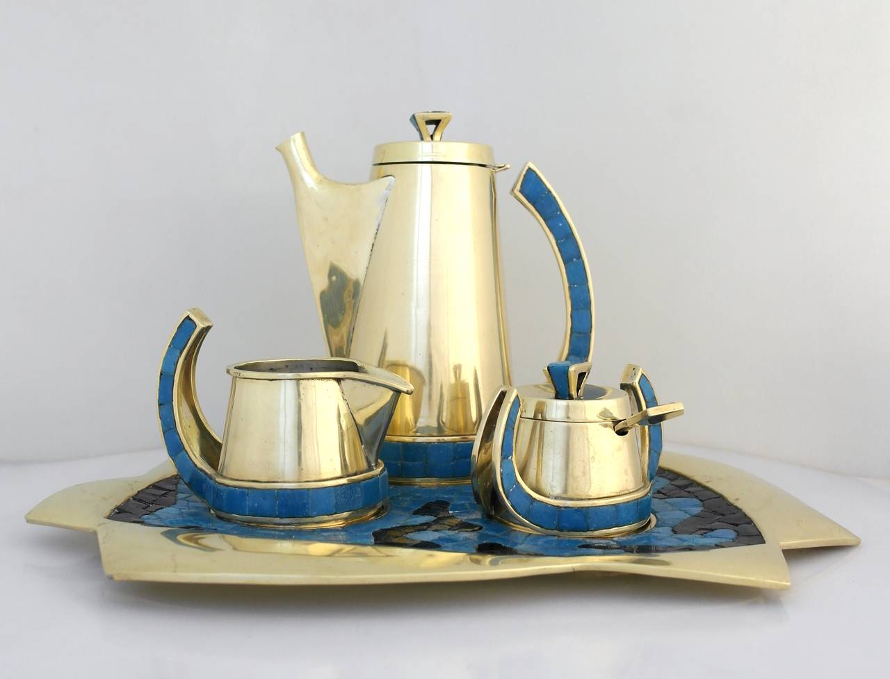 Being offered is an early and rare circa 1970s coffee set by Salvador Teran of Taxco, Mexico, hand-wrought brass and glass mosaic tile coffee service includes coffee server, sugar bowl with lid and spoon, creamer and tray. Marked. In excellent