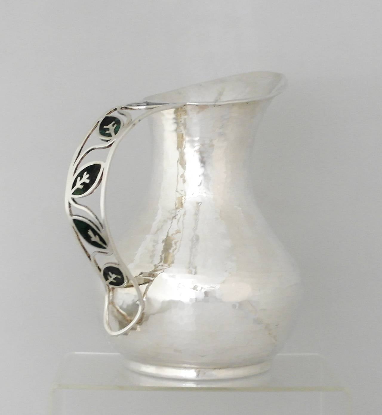 Being offered is a contemporary sterling silver pitcher by Manuel Porcayo of Taxco, Mexico. Porcayo, a long time smith for Emilia Castillo, continued in the Castillo tradition of designing quality hand made objects when he opened his own studio.