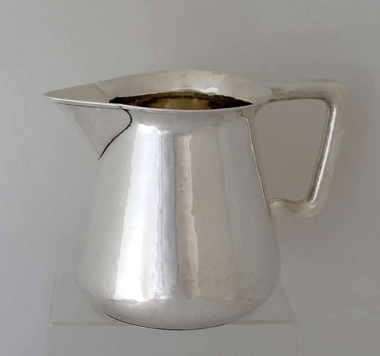 Being offered is a fine circa 1908 sterling silver salad pitcher by LeBolt of Chicago, IL, in the arts & crafts style, cylindrical form with angular handle & everted rim; hand hammering throughout.  Dimensions: 6 1/2 inches height. Marked as