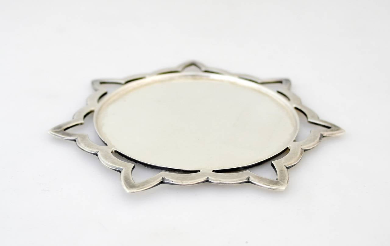Being offered is a circa 1975 sterling silver wine coaster by Henry Petzal, handmade object with a seven pointed star pierced motif surrounding the circular dish. Dimensions 5 inches diameter. Weight a hefty 5 oz. Marked in excellent condition.
  