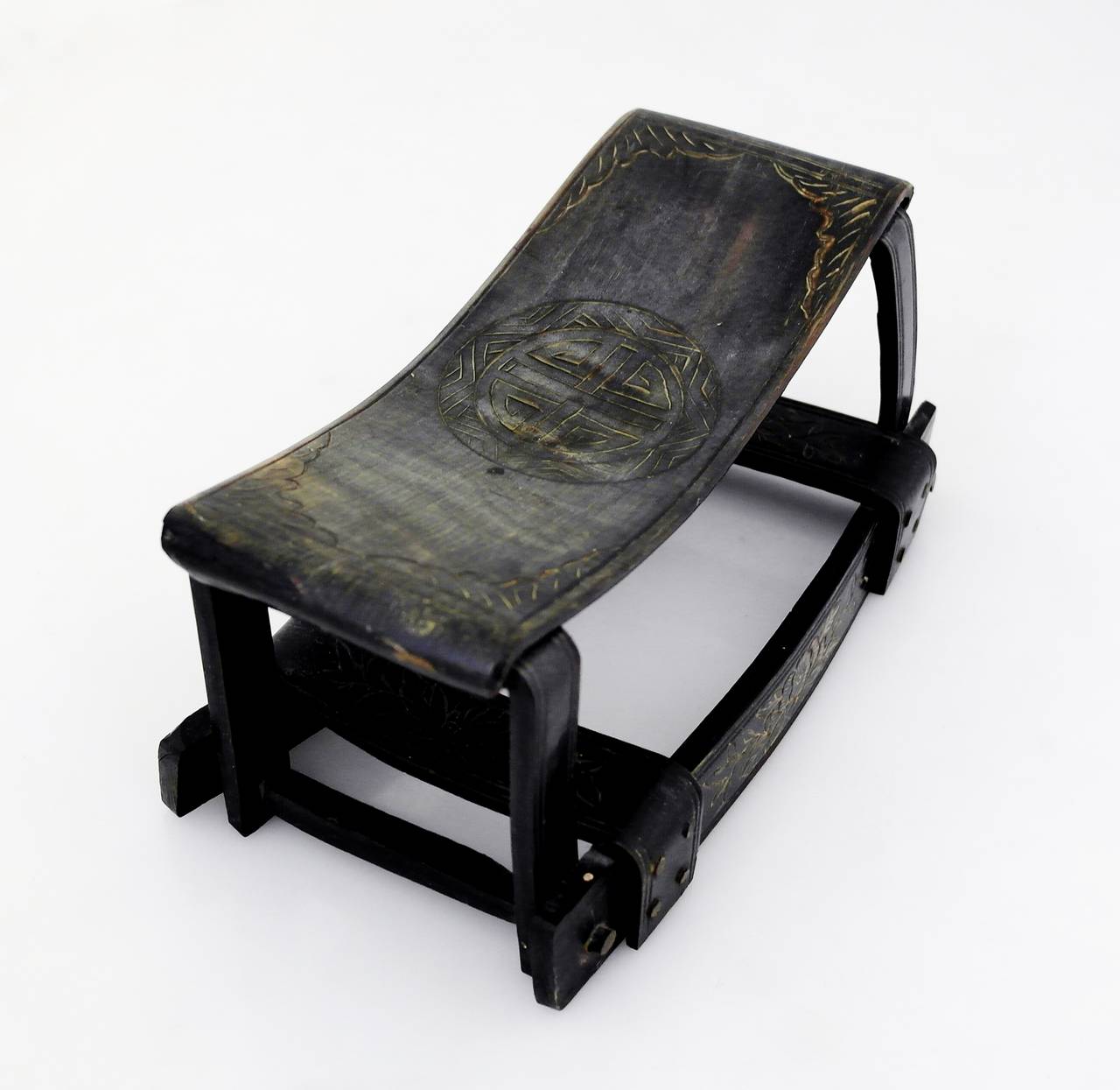 Being offered is a circa 19th century Chinese pillow made of horn; likely made in 1825 during the Qing dynasty (1644-1911), this rare example is decorated with hand-carved floral motifs and a Chinese symbol at the headrest. Dimensions: 8 1/4