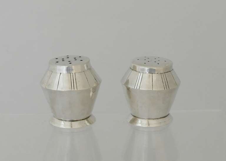 Being offered are a pair of circa 1953 sterling silver salt & pepper shakers by William Spratling of Taxco, Mexico. Made during his third design period (1951-1967); of modernist design with vertical incised lines as the primary decorative element,