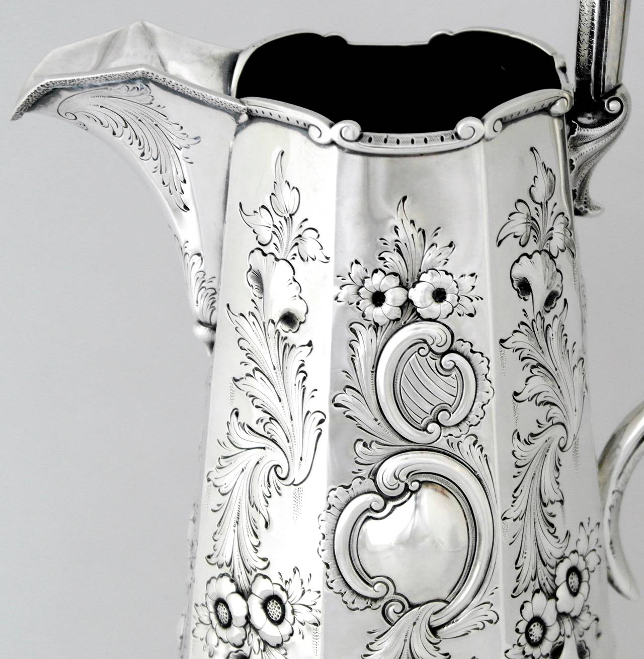 Being offered is a scarce circa 1840 coin silver pitcher by Robert & William Wilson of Philadelphia, Pennsylvania, comprising incredible hand chased foliate on the octagonal shaped pitcher, large square handle supported by four intricate feet.
