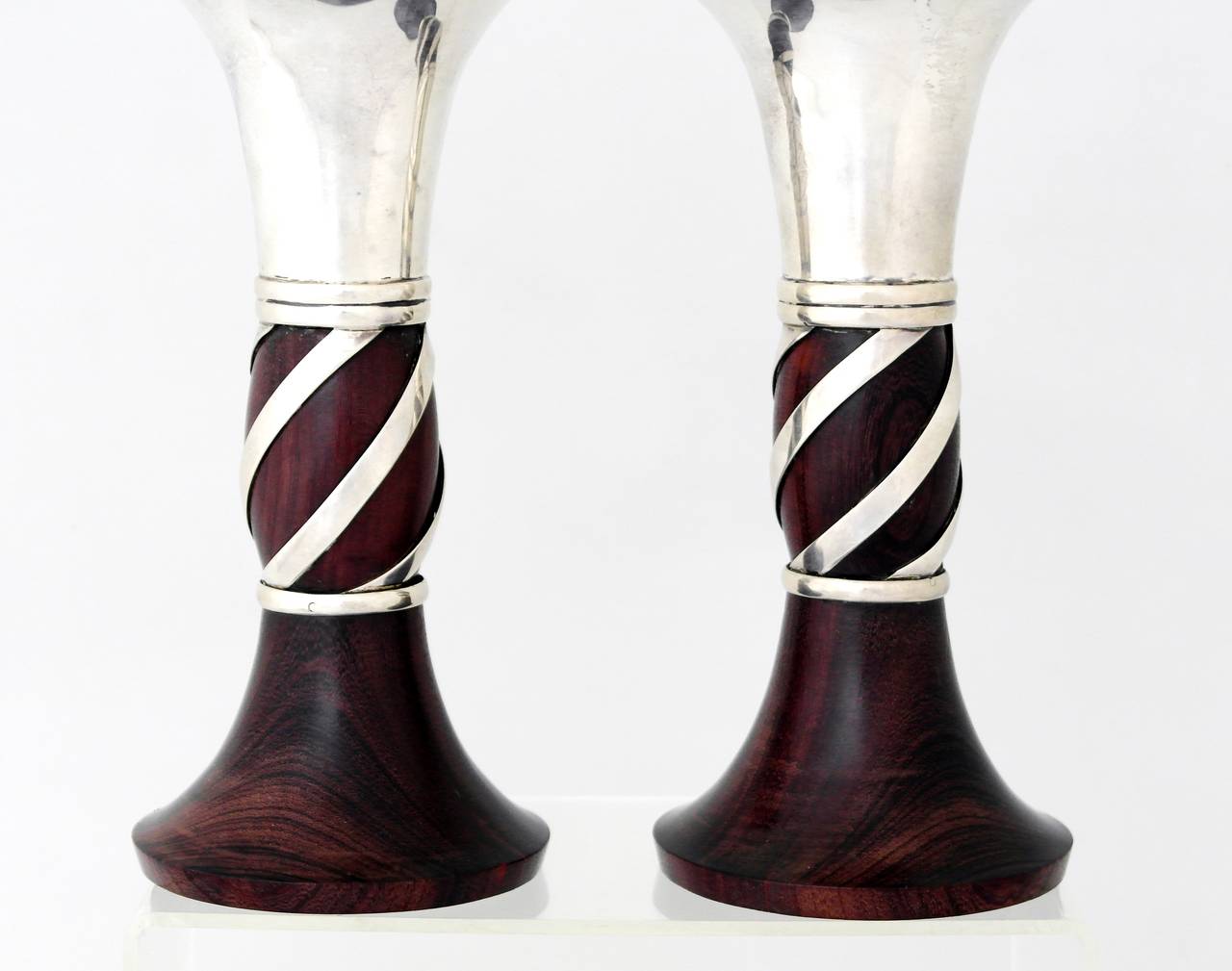 Being offered are a pair of cirda 1950 sterling silver candlesticks by William Spratling of Taxco, Mexico. Horn shaped with wrapped silver wire at the center; rosewood bases. Dimensions: 7 1/8" height; 3 1/2 inch dimater at top. Marked as