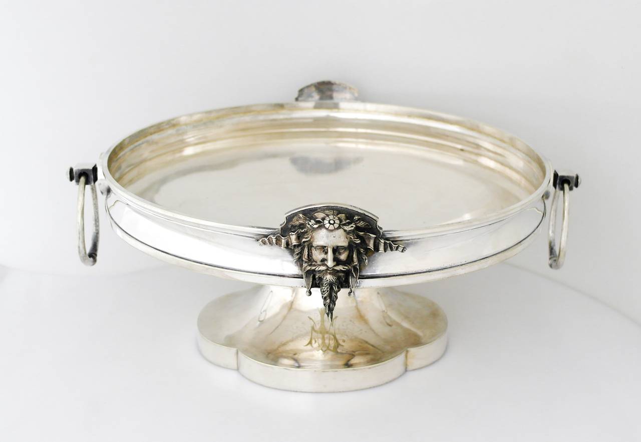 Being offered is a massive circa 1871 centerpiece by Gorham of Providence, Rhode Island. Impressive footed bowl with two loop handles at opposite ends; two applied faces of Zeus as the primary decorative element. Dimensions: 15 1/2 inches wide by 7