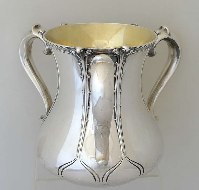 Being offered is a circa 1907 sterling silver  wine cooler - centerpiece by Tiffany & Company of New York, New York, the bulbous body with three handles, engraving at bottom and applied verticle ribbing.  The interior maintains its original gilding.
