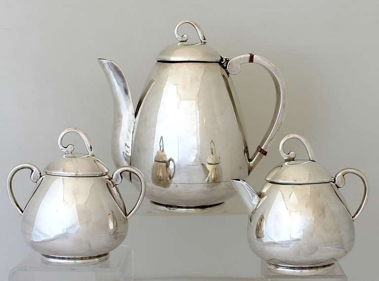 Being offered is a circa 1950 sterling silver coffee/tea set by Juvento Lopez Reyes of Mexico City, in the moderne design, the elegant bulbous bodies formed with a Danish style finial and elegant elongated spouts.  Dimensions:  the pot which can be