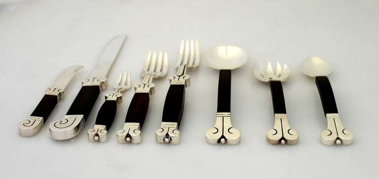 Being offered is a circa 1945 sterling silver and rosewood flatware set by Hector Aguilar of Taxco, Mexico; in the Aztec pattern; large service for 12, including scarce pieces. 
Set includes the following:
12 butter knives - 5 1/4