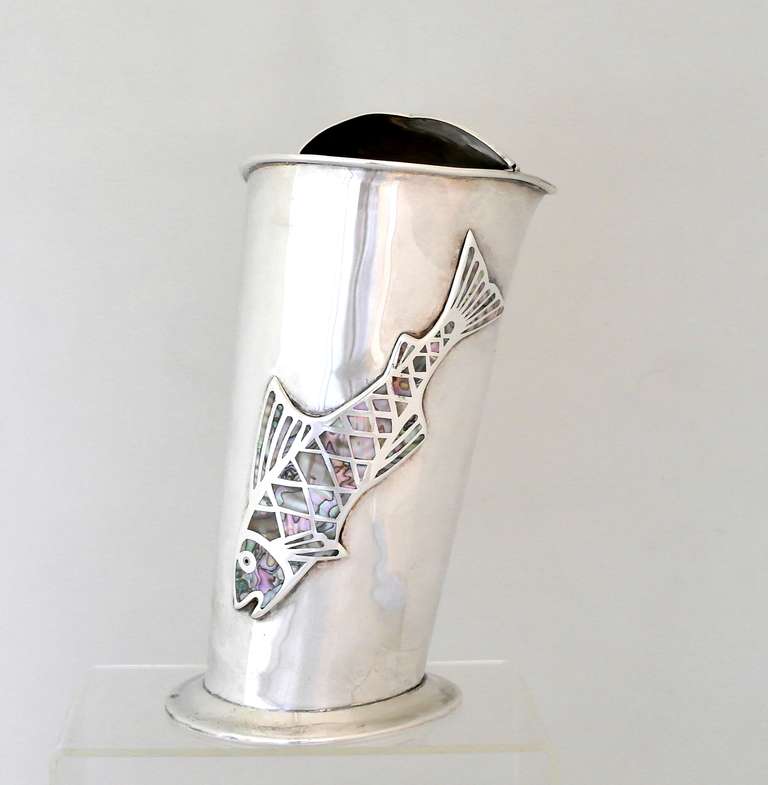 Being offered is a fine contemporary silverplate pitcher by Los Castillo, of Taxco, Mexico; unusual shaped modernist piece with two applied fish motifs; abalone inlaid detail on both; slightly raised on a pedestal foot. Dimensions: 9