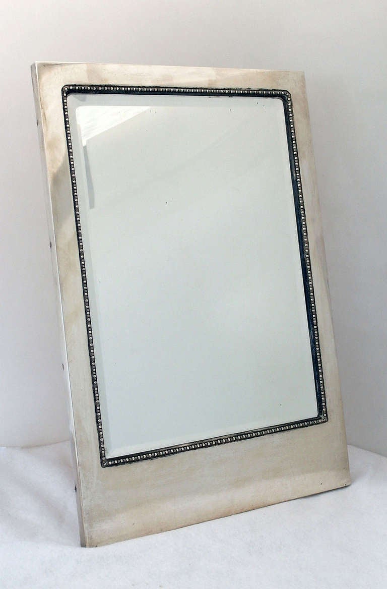 Being offered is a rare circa 1920 large Austrian .800 silver framed mirror from Vienna, in the Art Deco motif, rectangular shaped with a beaded interior border, resting on a sturdy wooden easel. Dimensions 18 3/4 inches high by 12 3/4 inches wide.