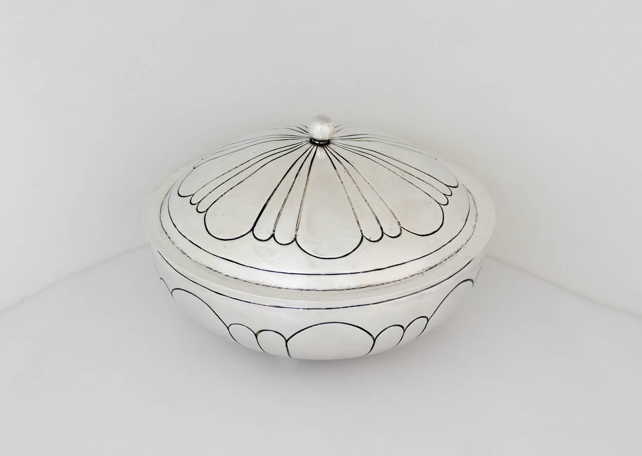 Being offered is a circa 1945 sterling silver bowl by the Maciel Factory of Mexico City. In the Art Deco taste, this handmade object boasts a modernist design using incised lines on the bowl, lid & ladle, ball finial, rests on four ball feet,