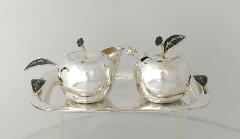 Being offered is a contemporary silverplate sugar & creamer set by Los Castillo of Taxco, Mexico. Interesting set in the shape of apples with detailed leaves bearing natural stone inlay; matching tray included. Dimensions: tray - 10
