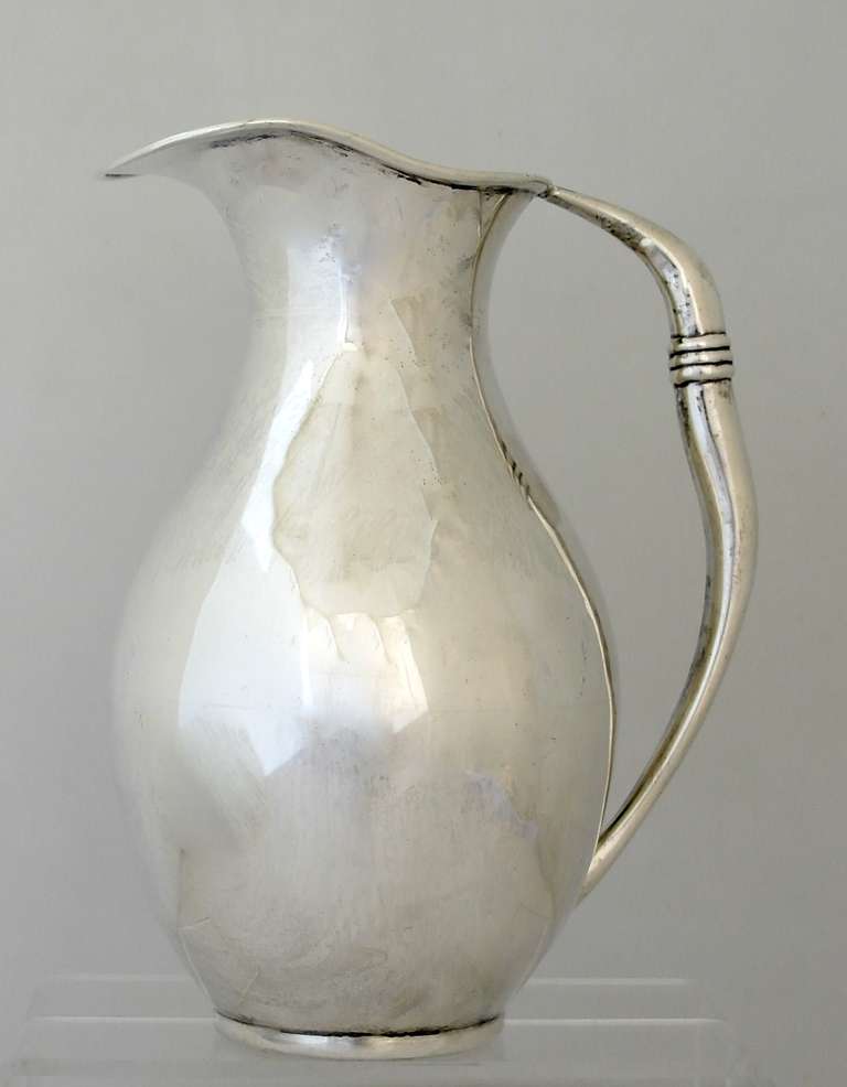 Being offered is a circa 1950s sterling silver water pitcher by C. Zurita of Mexico City. Baluster form with a wide rim & curved handle with chased bands. Dimensions: 9 1/2