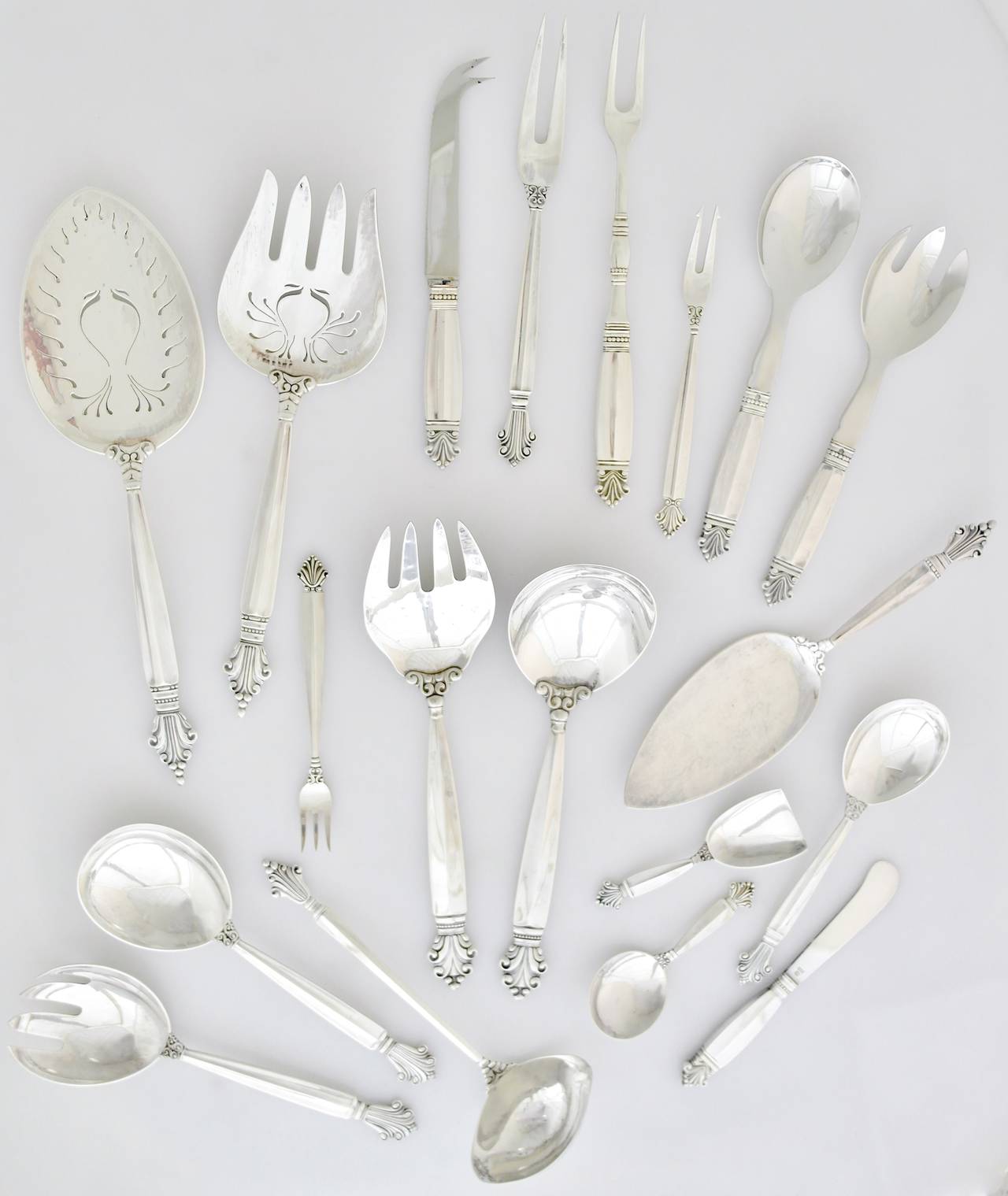 Offering a large sterling silver flatware set by Georg Jensen of Denmark, comprising a place setting of 13 pieces for 12 guests including many rare and hard to find serving pieces. The Acanthus pattern was designed by Johan Rohde in 1917.  The Acorn