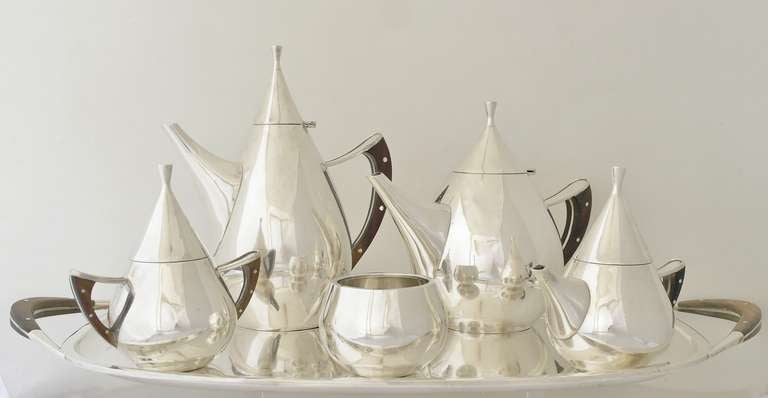 Being offered is a circa 1958 sterling silver coffee & tea set by Codan of Mexico; impressive Danish inspired design, tear drop shaped vessels with applied rosewood handles. Set includes a coffee pot, teapot, sugar, creamer. waste bowl & serving