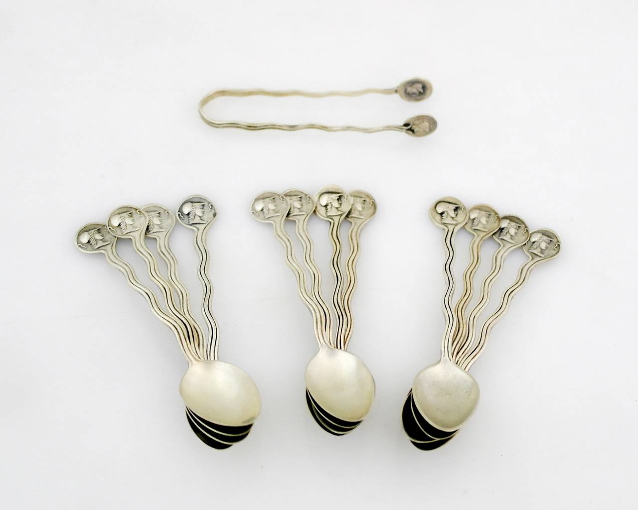 Being offered is a superb, circa 1864 coin silver demitasse set by Gorham of providence, Rhode Island, comprising 12 demitasse spoons with handles in a wave design leading to an embossed medallion. Sugar tongs are decorated similarly. Set includes