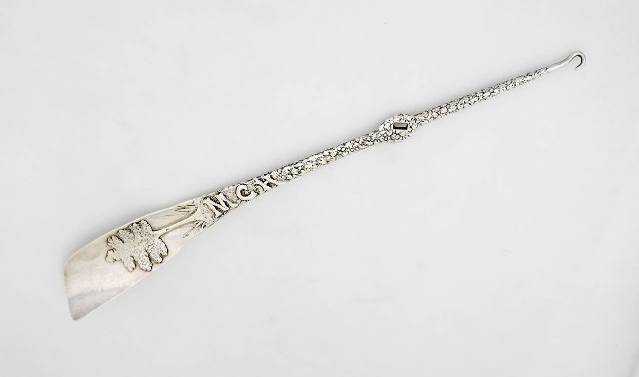Being offered is a large circa 1890 sterling silver shoehorn by George Shiebler of New York. The hammered silver shoe Horn with textured handle and applied tree to heel, button hook at opposite end of handle; applied monogram MCH. Dimensions: 15