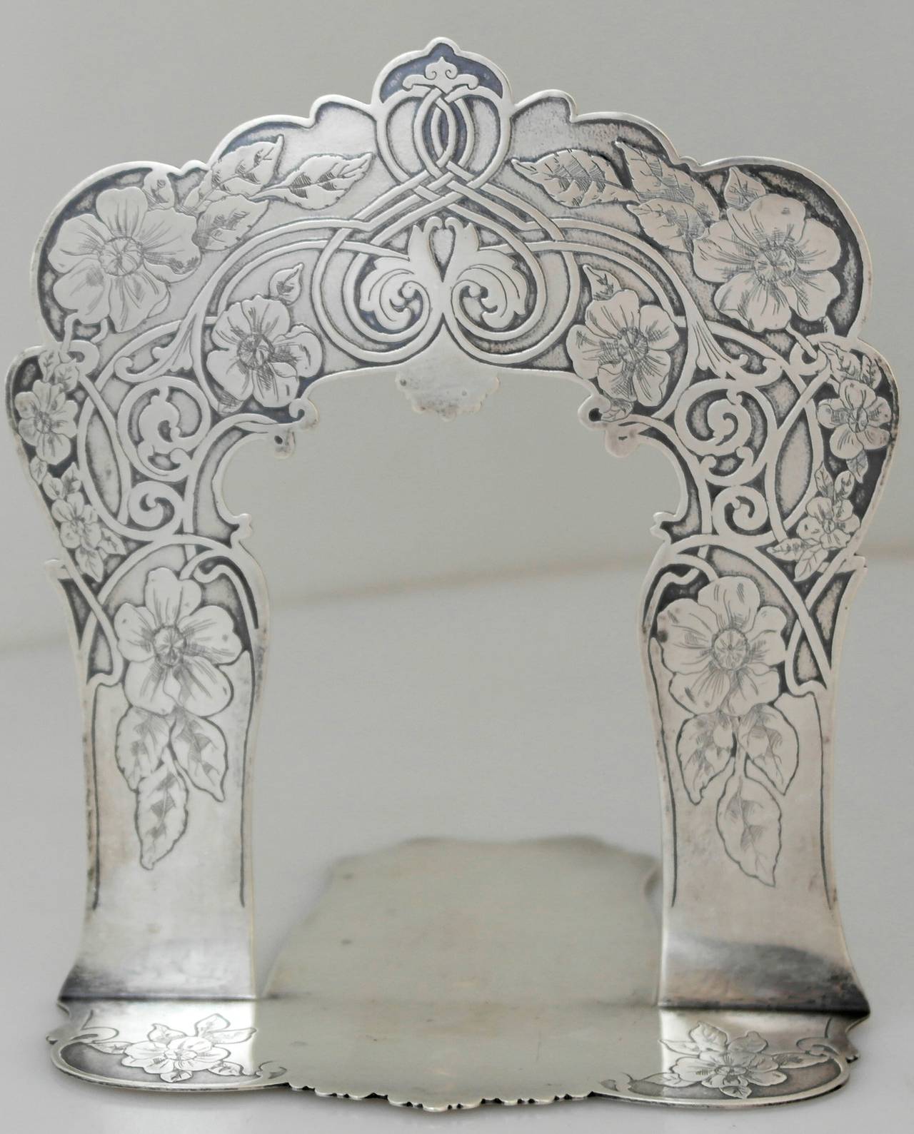 Being offered is a pair of circa 1905 sterling silver bookends by Tiffany & Co. of New York. Scarce pair of bookends made during the directorship of Charles T. Cook; with a masterful acid-etched floral and scroll design. Dimensions: 6