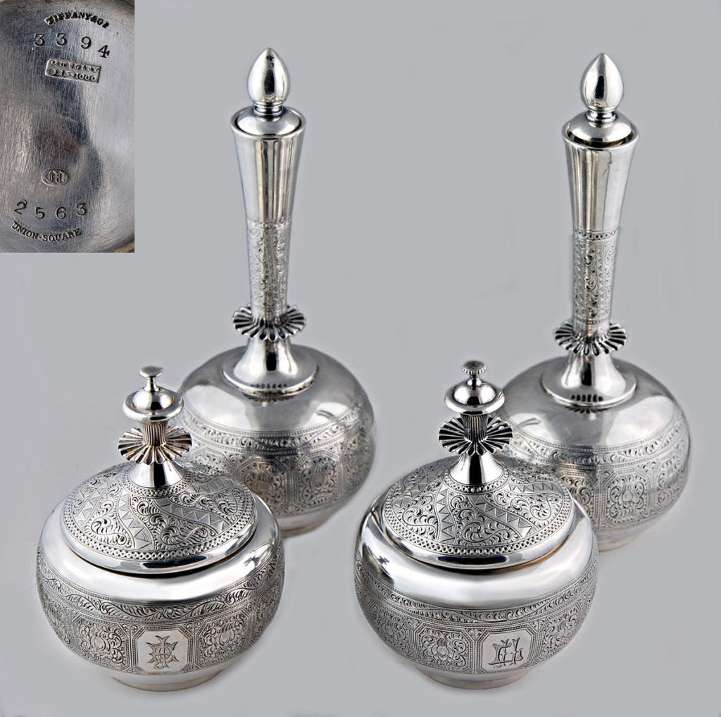 Being offered is a rare set of four (4) circa 1873 sterling silver ladies' dresser jars by Tiffany & Co. of New York, pairs of two (2) different sized jars - decanter type bottles -- one pair squat and bulbous, the other pair with a long slender