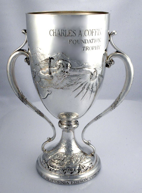 One-of-a-kind circa 1925 sterling silver 2-handle trophy by Redlich & Co. of New York, with a superbly chased male figure carrying power lines with one arm, and the other arm holding a mechanism sending out bolts of light--to Southern California,