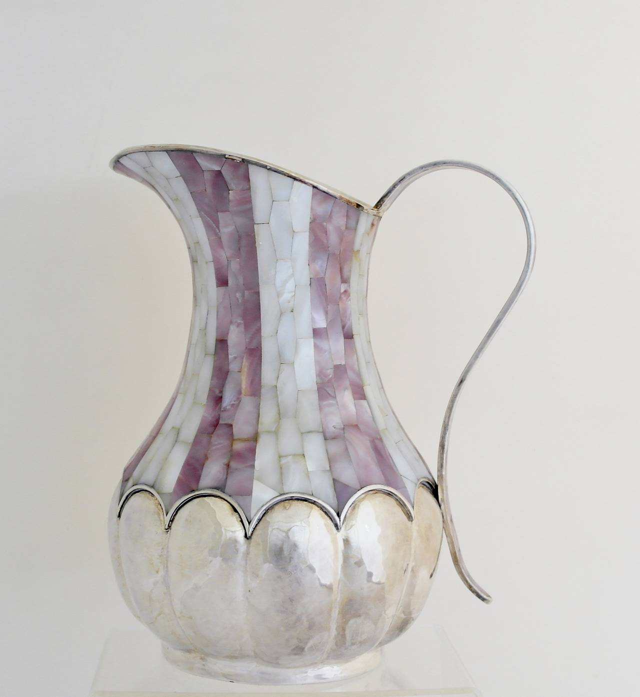 Being offered is a large circa 1990 pitcher by Los Castillo of Taxco, Mexico, bulbous shape with mother of pearl inlay, curved handle, wide spout. Dimensions 10 1/2 inches high. Marked as illustrated. In excellent condition.