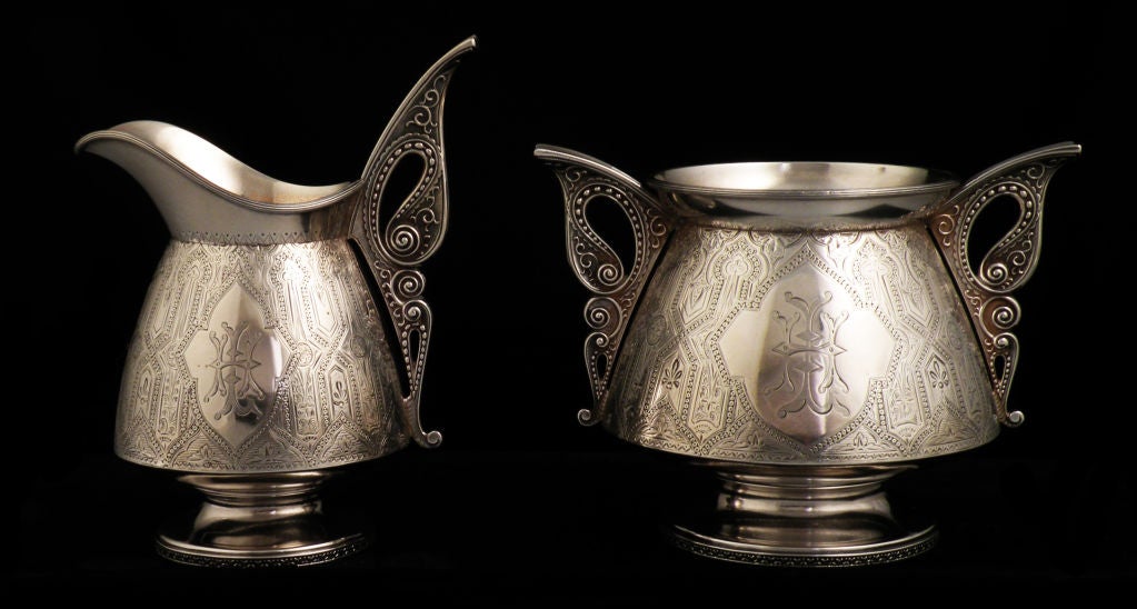 Fine Tiffany & Co. circa 1874 sterling silver creamer and sugar bowl in the Persian motif, with superb multi-pattern engraving over entire bodies, with butterfly-like, pierced handles, all on raised pedestal bases.  Dimensions:  bowl 5 1/2 inches