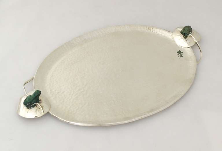 Being offered is a circa 1990 serving tray by Emilia Castillo of Taxco, Mexico, hammered all over with two lily motif handles featuring applied malachite-like stone frogs.  Dimensions 14 1/2 inches long by 9 inches wide.  Marked.  In excellent