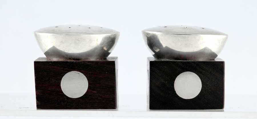 Sterling silver and ebony salt and pepper shakers by William Spratling of Taxco, Mexico, typical of the third period with sterling silver disks embedded in the ebony, circa 1960.

Dimensions 1 3/8 inches by 1 3/8 inches square by 1 1/2 inches high.