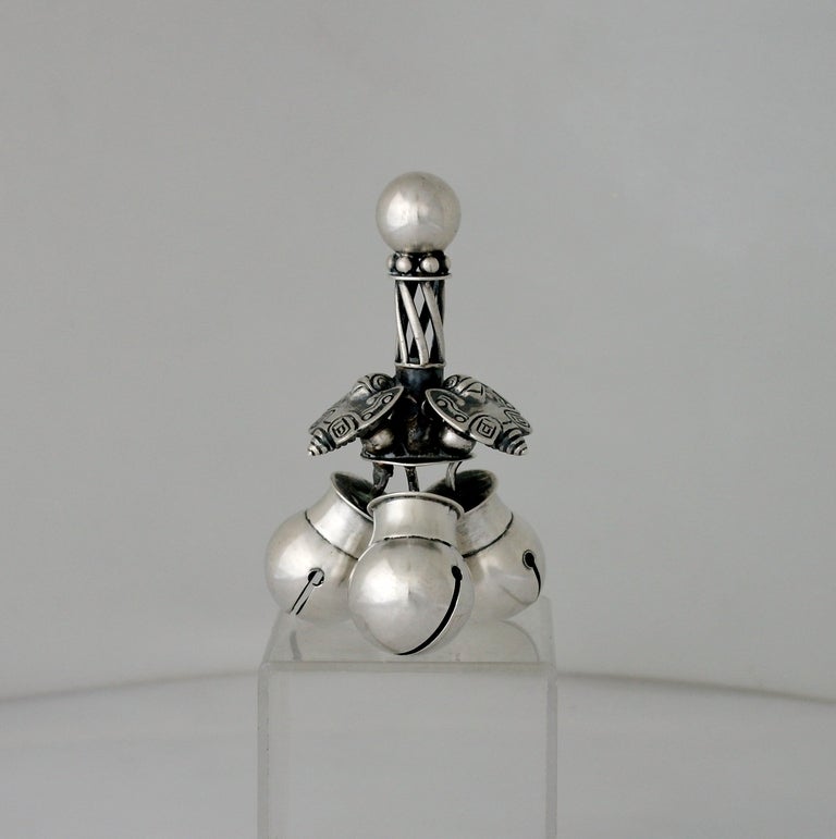 Being offered is a circa 1965 sterling silver dinner bell by William Spratling of Taxco, Mexico, designed as a Mayan rattle, three (3) bees surround a twisted open handle above slit spherical bells.  The bell's sound is remarkably beautiful -- like