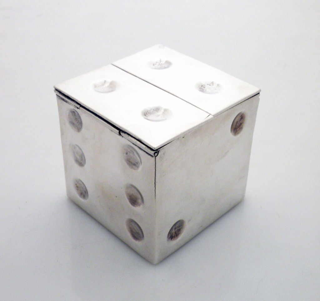 Being offered is an exceedingly rare circa 1940-44 sterling silver flip lid ash tray by William Spratling, of Taxco, in a chased dice design and shaped motif, the double lid of one side flips to accommodate four (4) cigarettes.  The guage of silver