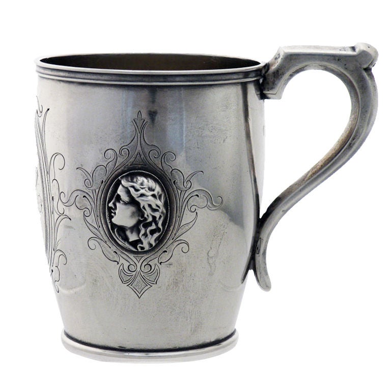 Being offered is a circa 1865 coin silver cup - mug by Peter L. Krider of Philadelphia, the body of the cup finely engraved, with two (2) different applied medallions, the monogram in a central cartouche, with applied lip at to top and bottom, with