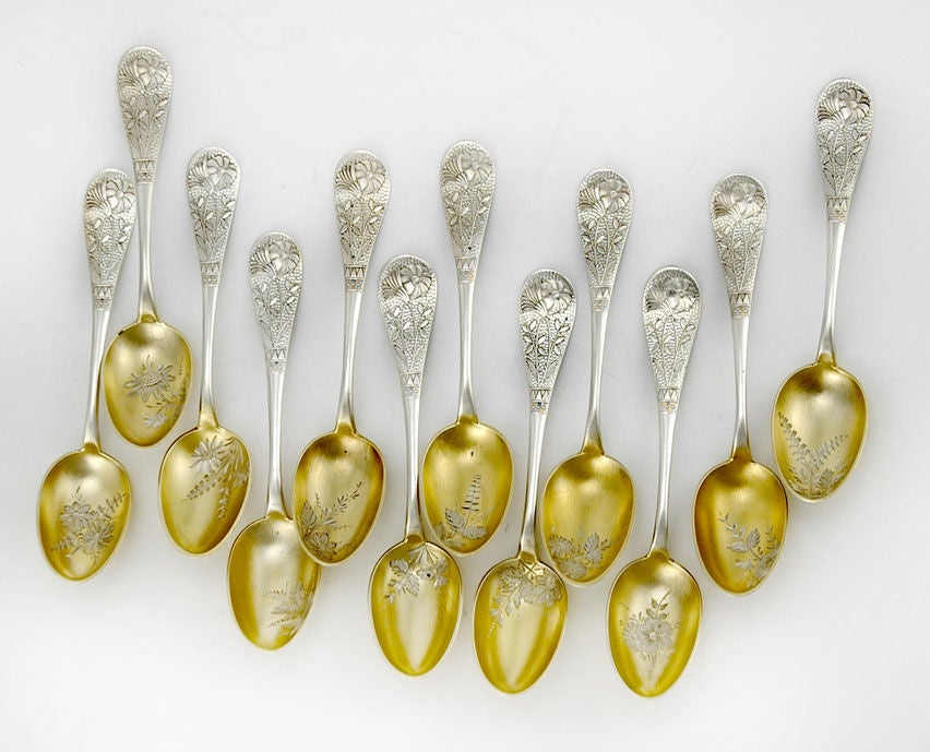 Rare set of twelve (12) circa 1880 sterling silver demitasse spoons by Wood & Hughes of New York, in the aesthetic or Japonesque taste, the stems superbly die cut in a floral and foliate design, the superbly gilded bowls engraved with more flowers,