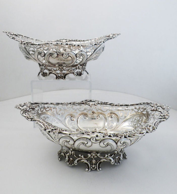 Being offered is a fine pair of circa 1892 sterling silver baskets by Howard & Co., of New York, each basket's body masterfully pierced, the scrollwork in a rococo revival motif, all on a raised, pierced and applied pedestal foot.  Dimensions 10 1/2