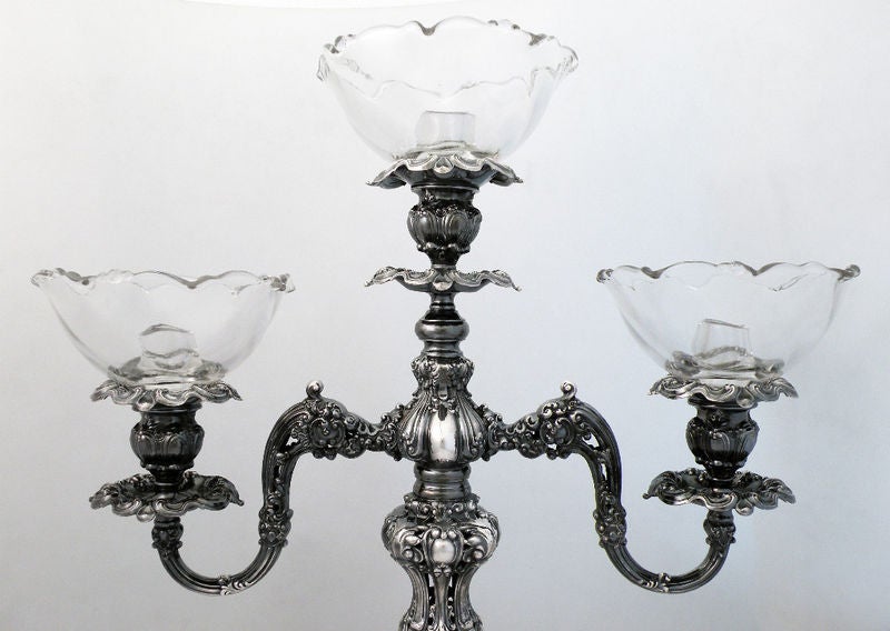 Being offered is a fine and important silver plated, circa 1895, three-candle candelabra, by Reed & Barton, of Taunton, MA, in a Renaissance revival motif, the bases and arms pierced, and featuring detailed elevations of swirls and fleur de lys-like