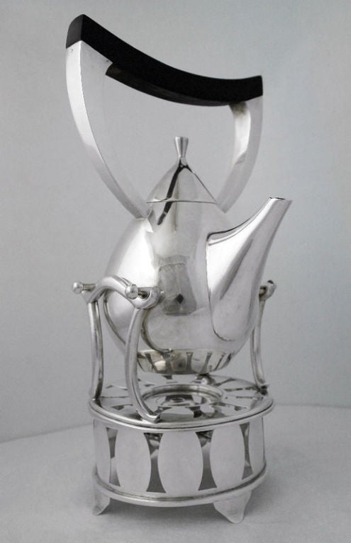Being offered is a circa 1945 sterling silver kettle on stand by Codan marked with Bernice Goodspeed's 'B', of Mexico, the kettle having teardrop-shaped body with upright angular silver and rosewood handle, center spout, set on a round stand with