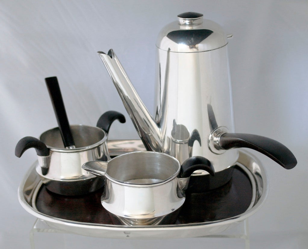 Being offered is circa 1950 sterling silver and rosewood personal coffee set, the pot with flip lid that has a rosewood handle and finial, the sugar bowl and creamer with rosewood handles, with matching sugar scoop and exceeling rare rosewood and