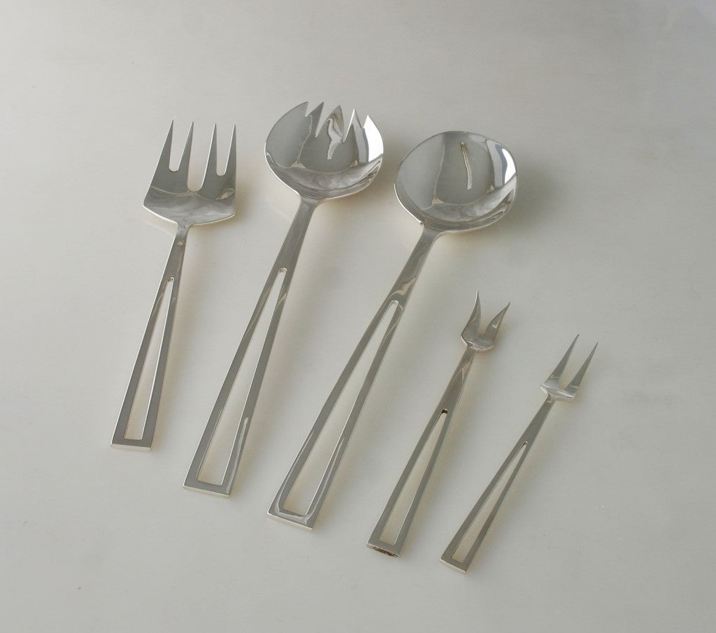 Being offered is an exceedingly rare, circa 1955 set of sterling silver flatware by Celsa, of Mexico, in the Avanti pattern. The pattern is a moderne geometric design with cut-out handles. The 91 pieces (and lengths) are listed below. Celsa had a