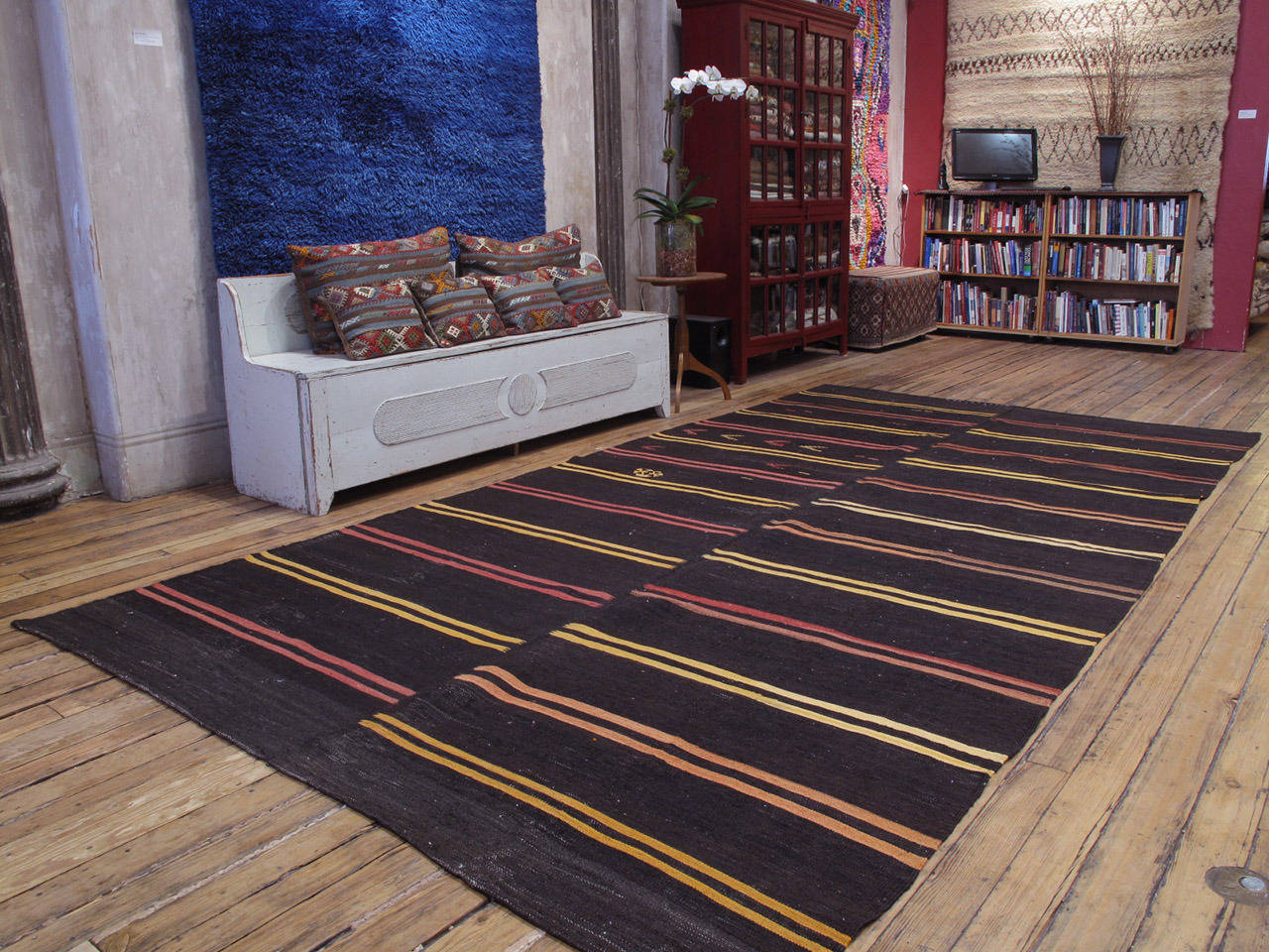 A large tribal floor cover from Southeastern Turkey, consisting of two panels stitched together. Woven with tightly spun, dark brown goat hair, decorated with colorful stripes and scattered brocaded motifs, this is a simple and primitive tribal