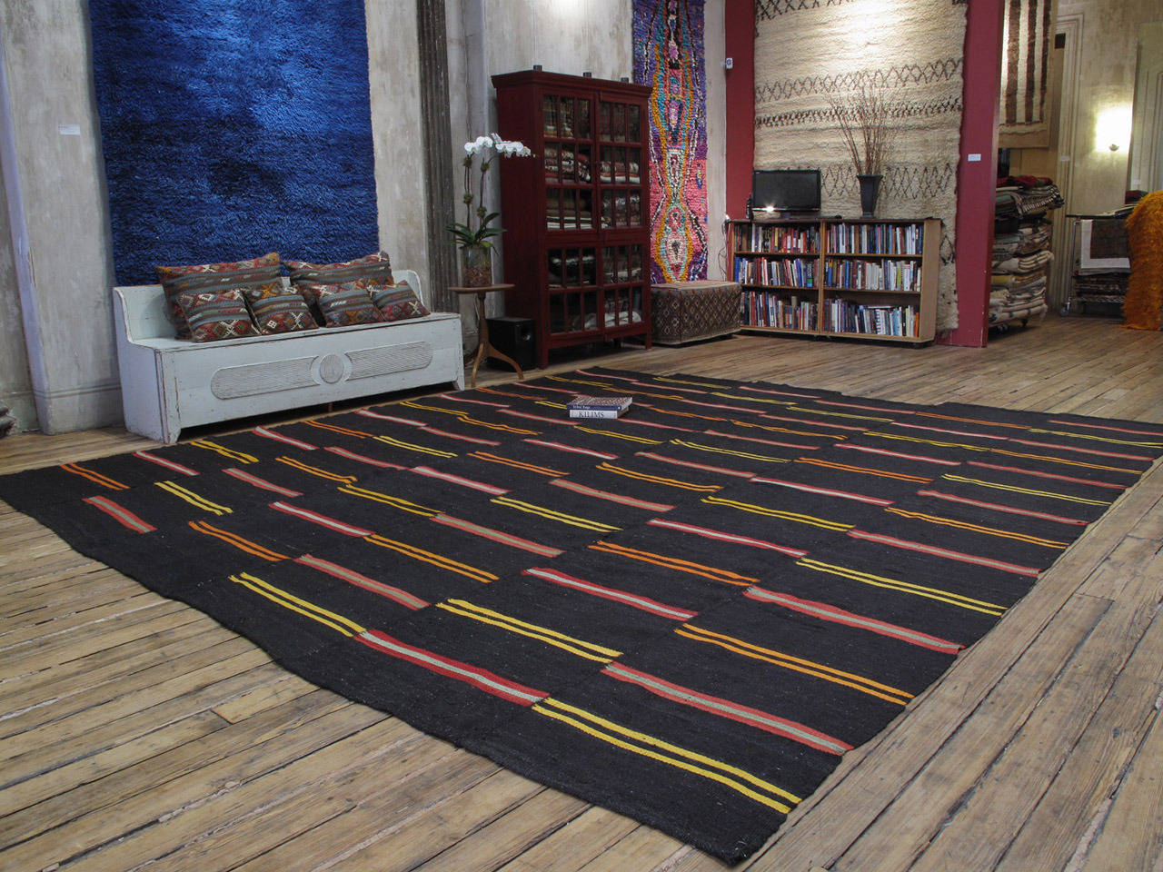 Large Kilim rug with bright stripes. A very heavy and sturdy tribal flat-weave rug from Southeastern Turkey in large format actually, a pair that we joined. Woven with dark brown goat hair and decorated with stripes in almost electric colors. With