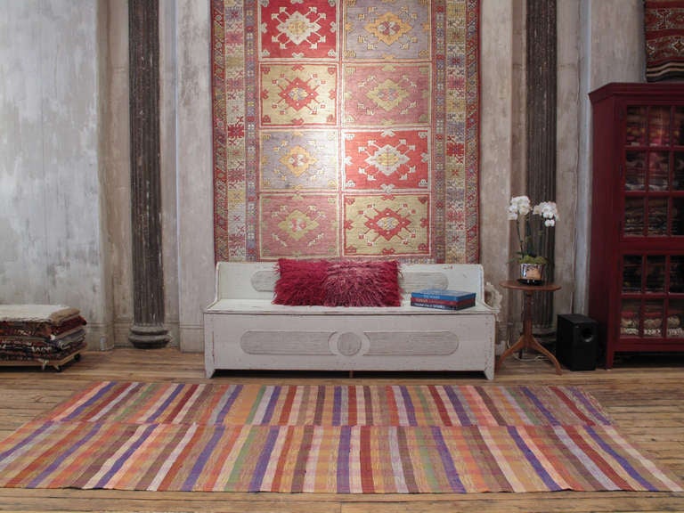 Colorful banded cover rug. A lovely old home-made textile rug from Turkey, woven on a narrow loom with colorful cotton yarn. It is sturdy enough for floor use as a rug in a low traffic area. Rug can also be used in a variety of ways and easily