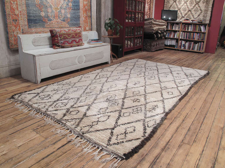 An old Moroccan Berber rug by the Beni Ouarain tribes of the Middle Atlas Mountains, who used these large rugs as beds in their tents and cottages.

The classic diamond grid design is executed with pleasing irregularities and a scattering of