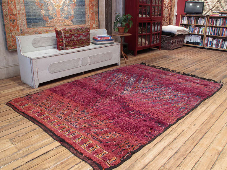 A great old Berber carpet from Morocco, woven by the Beni Mguild tribes of the Middle Atlas Mountains. An earlier example featuring a well-known design type in richly saturated tones of red, purple and orange.

Though less famous than their