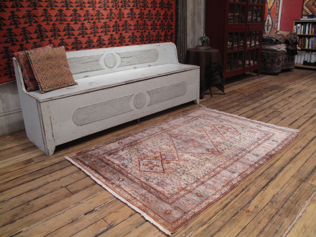 An old Turkish rug with original pale color palette. The rug was woven with mercerized cotton, which was used to imitate silk, and therefore has a silky sheen.
