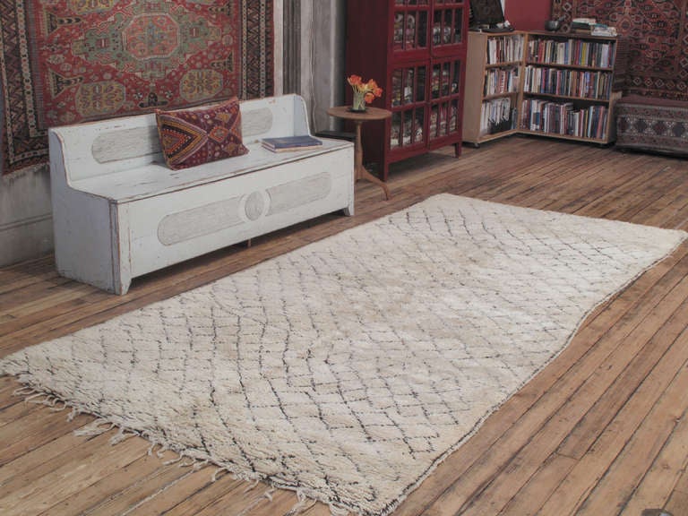 A great old example of Moroccan Berber weaving, attributed to the Beni Ouarain tribes of the Middle Atlas Mountains, who used these as beds. The diamond grid pattern, a well-known Berber theme, is executed in small scale here with several