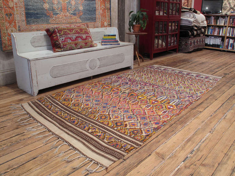 An older example of Moroccan Berber weaving from the High Atlas Mountains, attributed to the region around Azilal. Richly decorated in great detail, it feels like a peacock's feathers or stained glass.

This is a very soft and loose weaving and is