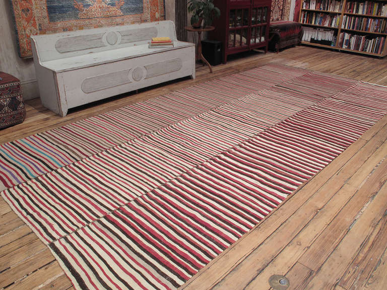 A beautiful old tribal floor cover, woven in three narrow panels with alternating colorful stripes, with pleasing irregularities inherent in the process of weaving by hand.

(Length can be adjusted. Please inquire).